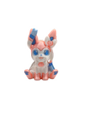 a pink and white cat figurine with blue eyes